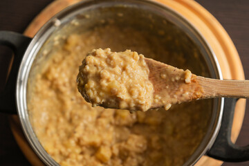 creamy pumpkin oatmeal with apple slices in a cooking pot