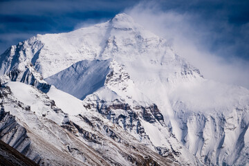 Aerial and ground views of Mount Everest from the Tibetan side. Majestic snow-covered peaks of the Himalayas rising above the high-altitude plateau under clear blue skies