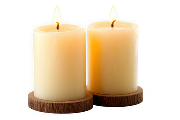 Two lit cream pillar candles on dark wood coasters against black background flame burning