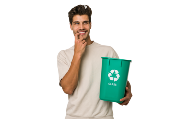 Young caucasian man holding a glass trash isolated relaxed thinking about something looking at a copy space.