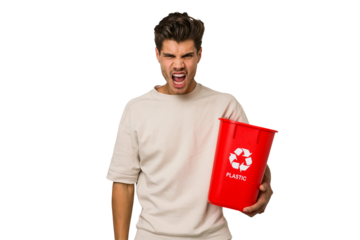 Young caucasian man holding a plastic trash isolated screaming very angry and aggressive.