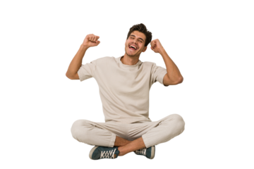 Young caucasian man sitting on the floor isolated on white background dancing and having fun.