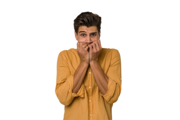 Young handsome caucasian man isolated on white background biting fingernails, nervous and very anxious.