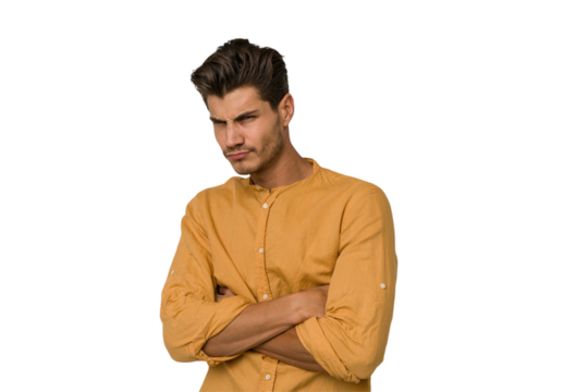 Young handsome caucasian man isolated on white background frowning face in displeasure, keeps arms folded.