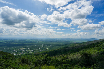 Image of a blue sky and some clouds with copy space for text. Cloudy blue sky abstract background, blue sky background with tiny clouds..A landscape featuring trees and hills. The image captures an o	