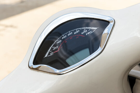 A detailed close-up of a scooter speedometer with chrome trim - Powered by Adobe