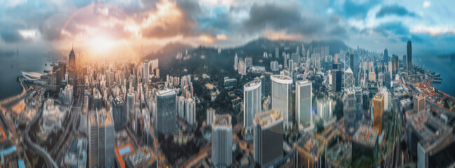 Panoramic double exposure showing a cityscape with a vibrant sky and high-rise buildings. The blurred effect and hazy light creates a dynamic, urban view.