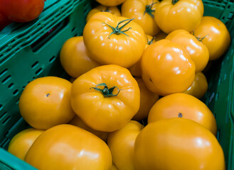 Yellow tomatoes in a vegetable crate at the market