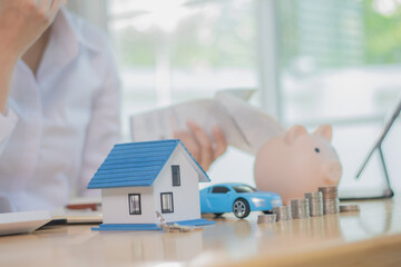 An anxious employee sits at a desk calculating taxes and mortgage payments, stressed about debt,...