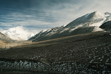 Aerial and ground views of Mount Everest from the Tibetan side. Majestic snow-covered peaks of the Himalayas rising above the high-altitude plateau under clear blue skies