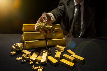 Male hands holding Gold Nuggets. Bank gold bars. Gold reserv holdings concept. Savings and...