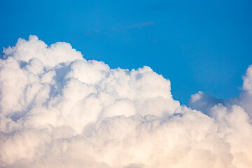 Background with cotton clouds in the blue sky. An idyllic landscape that brings peace and tranquility.