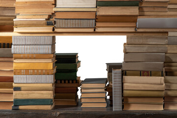 Obraz premium Stacks of many books on a shelf or table on an isolated background. Concept of library, reading, old classic literature