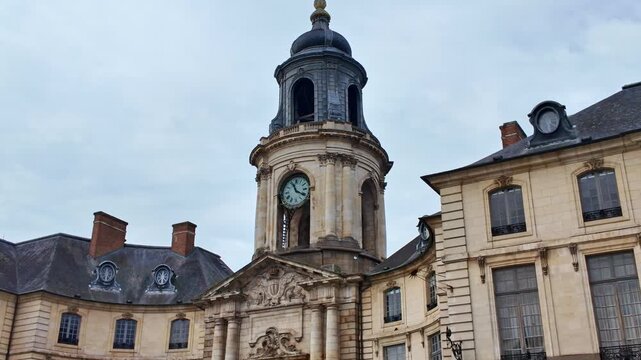 The iconic Cock tower of H&ocirc;tel de Ville in Rennes, France, features Roman numerals and intricate stonework beneath a domed roof, push-in shot emphasizing neoclassical architectural details