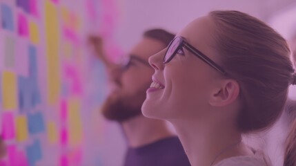 A group of people engaged in an interactive brainstorming session, facing a colorful wall covered with sticky notes,