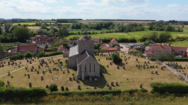Ariel footage of Burnham Overy Staithe Mill in Norfolk England on the river Burn. Overy Water Mill, Windmill. Rural summer scene.