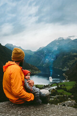 Dad with infant baby traveling in Norway family vacations outdoor sightseeing Geiranger fjord...