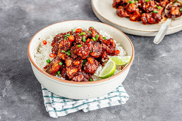Stir-Fried Chicken Over Rice Garnished with Lemon and Scallion Close-Up Asian Food Photo