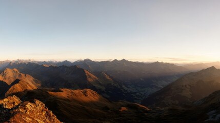 Naklejka premium Dramatic mountain panorama bathed in golden sunset light,