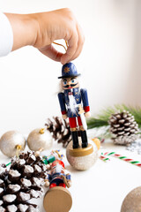 Child holding nutcracker ornament amid festive Christmas decorations