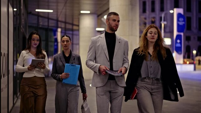 Group of professional business associates walking and talking after work in a vibrant urban environment.