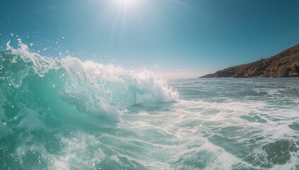 Fototapeta premium Crashing turquoise ocean wave creating white foam and spray in coastal seascape, with sun glare
