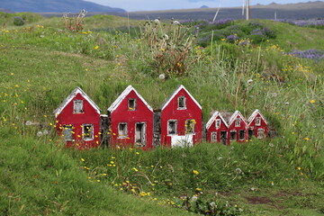 tiny red wooden replicas of icelandic elves houses near Strandarkirkja in south iceland