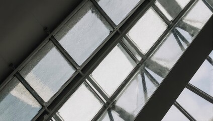 Obraz premium Geometric Glass Roof Structure with Metal Beams and Natural Light.