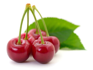 Fresh red cherries with green leaves isolated on white background