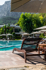 Relaxing by the serene poolside surrounded by lush greenery and mountains in a tranquil resort setting