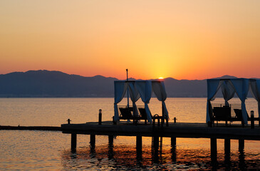 Sunbeds on a pier at sunset