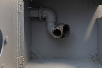 Gray cabinet with a metal pipe and two outlets in an industrial setting