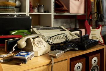 Vintage electronics including rotary phone, typewriter, retro video game console, and audio...