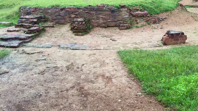 A tilt-up shot revealing the excavated brick and stone foundation of the ancient Bharhut Stupa in Madhya Pradesh, showcasing remnants of its circular base from the Shunga period.