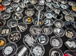 Variety of mechanical components organized in clear containers on a black surface for easy...