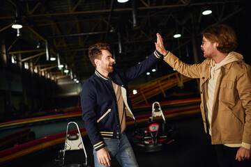 Friends celebrate victory after a thrilling karting race in an indoor track