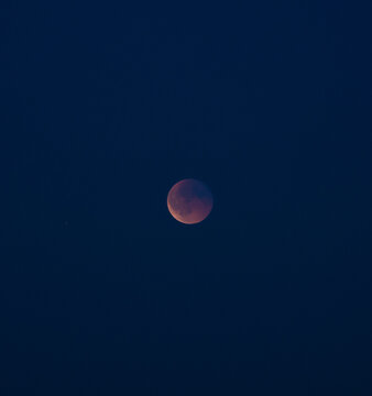 blood moon or crimson moon during total lunar eclipse in the dark night sky