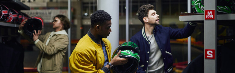 Exciting moment of friends preparing for karting adventure in vibrant indoor track