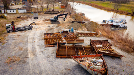 Aerial view on excavator and tow truck as they move part of vessel