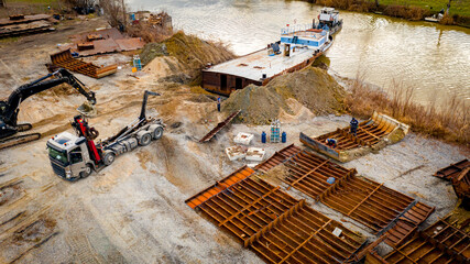 Aerial view on excavator and tow truck as they move part of vessel