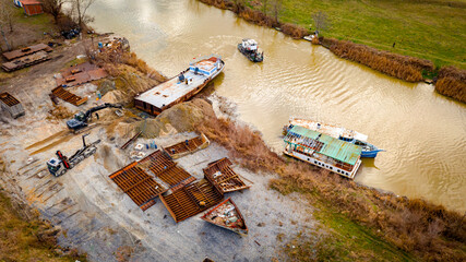 Aerial view on excavator, tow truck and tugboat as they move part of vessel