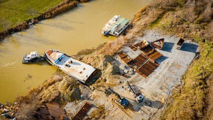 Aerial view on excavator, tow truck and tugboat as they move part of vessel