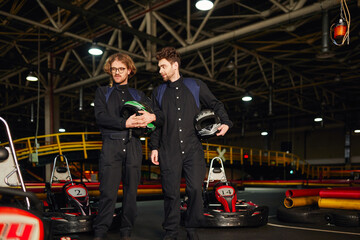 Friends enjoy their leisure time at the karting circuit with helmets in hand