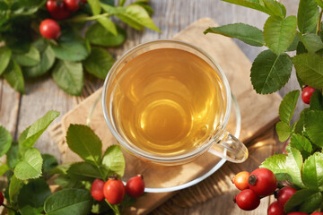 A cup of rose hip tea with fresh berries on a table