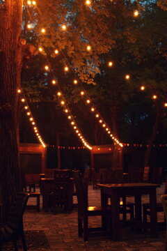 Cozy outdoor cafe terrace decorated with glowing string lights 