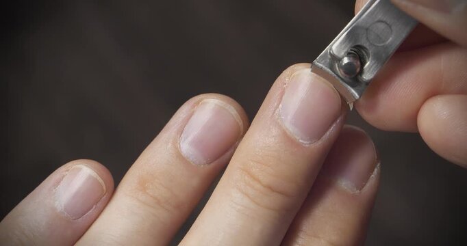 Man cuts fingernails using nail clipper, close-up video. Man cutting his long middle fingernail