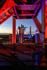 Industrial structure glows with vibrant red and blue lights
