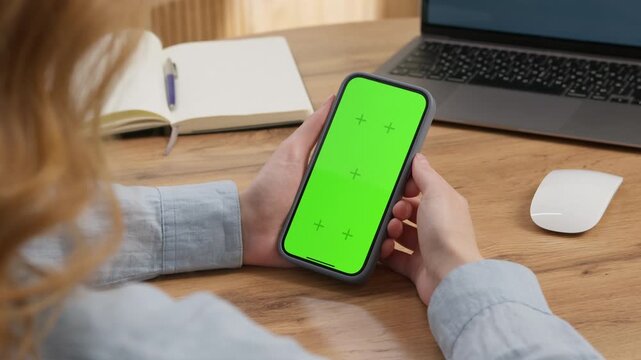 Woman sit use digital tech cell phone open green screen mock up. Hand scroll phone web site swipe unlock. Girl hold mobile closeup. Turn on chroma key page Cozy home background. Online app copy space