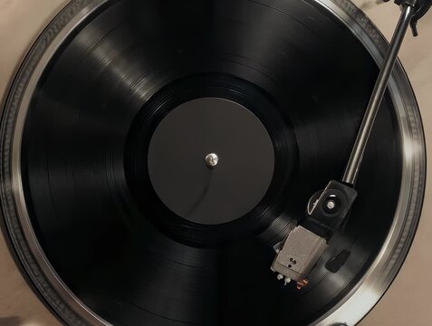 Overhead shot of a record player with a spinning black vinyl record and a tonearm