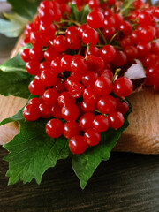Fresh red berries with green leaves on wooden board, perfect for autumn, rustic, and organic themes.